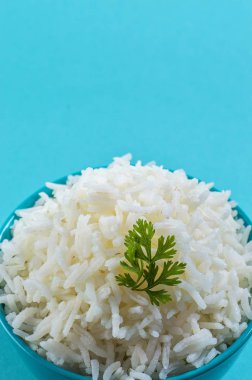 Düz beyaz basmati pilav corriander mavi zemin üzerine mavi bir kase ile pişmiş