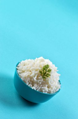 Düz beyaz basmati pilav corriander mavi zemin üzerine mavi bir kase ile pişmiş