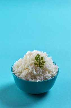 Düz beyaz basmati pilav corriander mavi zemin üzerine mavi bir kase ile pişmiş