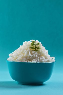 Düz beyaz basmati pilav corriander mavi zemin üzerine mavi bir kase ile pişmiş