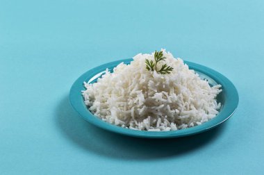 Düz beyaz basmati pilav corriander mavi zemin üzerine mavi bir plaka ile pişmiş