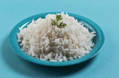 Düz beyaz basmati pilav corriander mavi zemin üzerine mavi bir plaka ile pişmiş