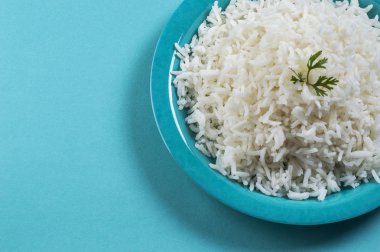 Düz beyaz basmati pilav corriander mavi zemin üzerine mavi bir plaka ile pişmiş