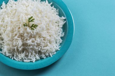 Düz beyaz basmati pilav corriander mavi zemin üzerine mavi bir plaka ile pişmiş