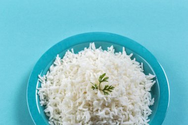 Düz beyaz basmati pilav corriander mavi zemin üzerine mavi bir plaka ile pişmiş