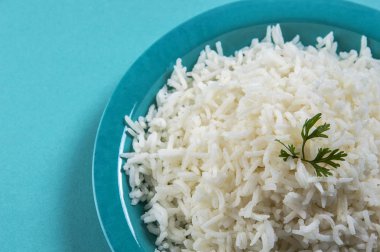 Düz beyaz basmati pilav corriander mavi zemin üzerine mavi bir plaka ile pişmiş