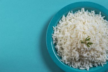 Düz beyaz basmati pilav corriander mavi zemin üzerine mavi bir plaka ile pişmiş