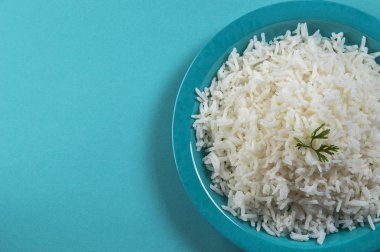 Düz beyaz basmati pilav corriander mavi zemin üzerine mavi bir plaka ile pişmiş