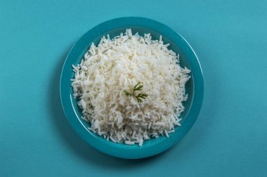 Düz beyaz basmati pilav corriander mavi zemin üzerine mavi bir plaka ile pişmiş