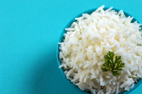 Düz beyaz basmati pilav corriander mavi zemin üzerine mavi bir kase ile pişmiş