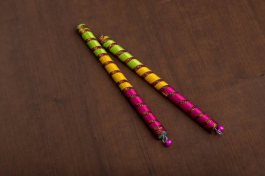 Dandiya kahverengi arka plana yapışır. Raas Garba ya da Dandiya Raas, Hindistan 'da Gujarat & Rajasthan eyaletinin geleneksel halk dansları türüdür..
