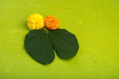 Dussehra Hint Festivali 'nde altın yaprak (Bauhinia racemosa) ve kahverengi arka planda kadife çiçekleri gösterilir..