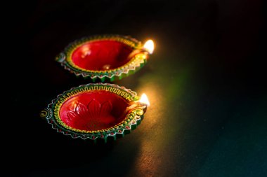 Mutlu Diwali 'ler. Diwali kutlamaları sırasında Clay Diya lambaları yandı. Hint Hindu Işık Festivali 'nin tebrik kartı tasarımı Diwali