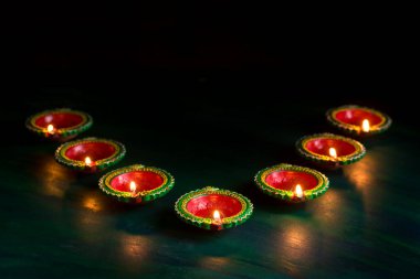 Mutlu Diwali 'ler. Diwali kutlamaları sırasında Clay Diya lambaları yandı. Hint Hindu Işık Festivali 'nin tebrik kartı tasarımı Diwali