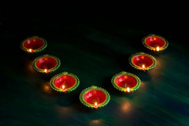 Mutlu Diwali 'ler. Diwali kutlamaları sırasında Clay Diya lambaları yandı. Hint Hindu Işık Festivali 'nin tebrik kartı tasarımı Diwali