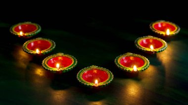 Mutlu Diwali 'ler. Diwali kutlamaları sırasında Clay Diya lambaları yandı. Hint Hindu Işık Festivali 'nin tebrik kartı tasarımı Diwali