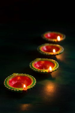 Mutlu Diwali 'ler. Diwali kutlamaları sırasında Clay Diya lambaları yandı. Hint Hindu Işık Festivali 'nin tebrik kartı tasarımı Diwali