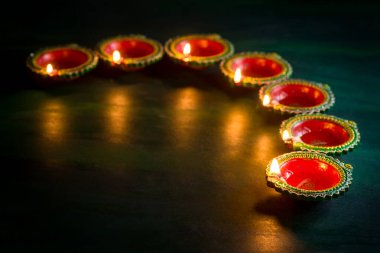 Mutlu Diwali 'ler. Diwali kutlamaları sırasında Clay Diya lambaları yandı. Hint Hindu Işık Festivali 'nin tebrik kartı tasarımı Diwali