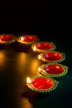 Mutlu Diwali 'ler. Diwali kutlamaları sırasında Clay Diya lambaları yandı. Hint Hindu Işık Festivali 'nin tebrik kartı tasarımı Diwali