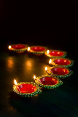 Mutlu Diwali 'ler. Diwali kutlamaları sırasında Clay Diya lambaları yandı. Hint Hindu Işık Festivali 'nin tebrik kartı tasarımı Diwali