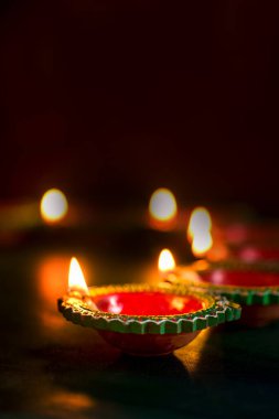 Mutlu Diwali 'ler. Diwali kutlamaları sırasında Clay Diya lambaları yandı. Hint Hindu Işık Festivali 'nin tebrik kartı tasarımı Diwali