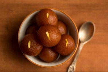 Gulab Jamun ahşap arka planda kasede. Hint Tatlısı ya da Tatlı Tabak.