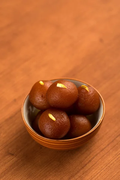Gulab jamun in einer Schüssel auf hölzernem Hintergrund. indisches Dessert oder süßes Gericht. — Stockfoto