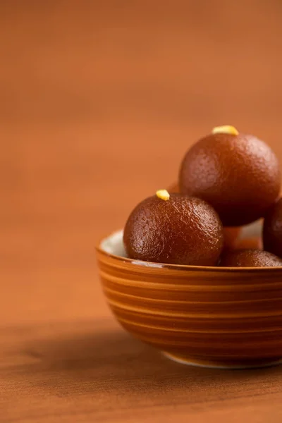 Gulab jamun in einer Schüssel auf hölzernem Hintergrund. indisches Dessert oder süßes Gericht. — Stockfoto