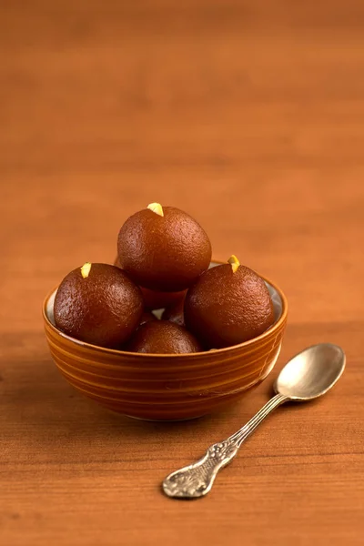 Gulab jamun in einer Schüssel auf hölzernem Hintergrund. indisches Dessert oder süßes Gericht. — Stockfoto