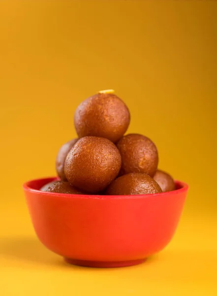 인도식 디저트나 달콤 한 음식: 노란색 배경에 놓인 그릇에 넣은 굴 따오기. — 스톡 사진