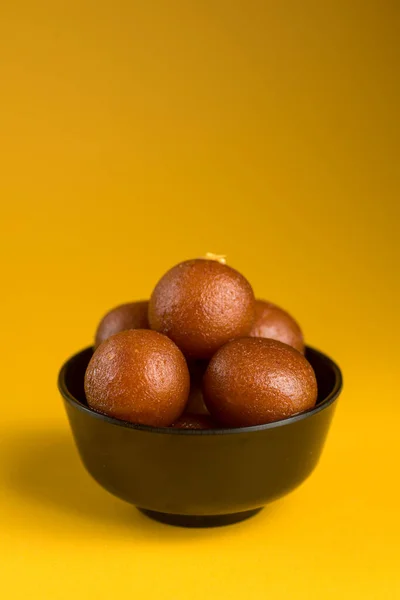 Indian Dessert or Sweet Dish : Gulab Jamun in bowl on yellow background. — Stock Photo, Image
