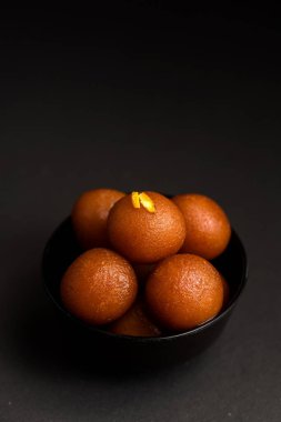 Gulab Jamun siyah arka planda kasede. Hint Tatlısı ya da Tatlı Tabak.