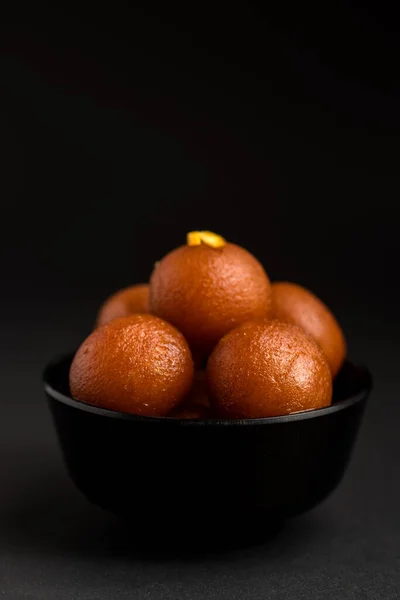 Gulab jamun in einer Schüssel auf schwarzem Hintergrund. indisches Dessert oder süßes Gericht. — Stockfoto