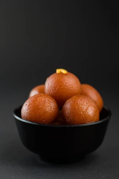 Gulab jamun in einer Schüssel auf schwarzem Hintergrund. indisches Dessert oder süßes Gericht. — Stockfoto