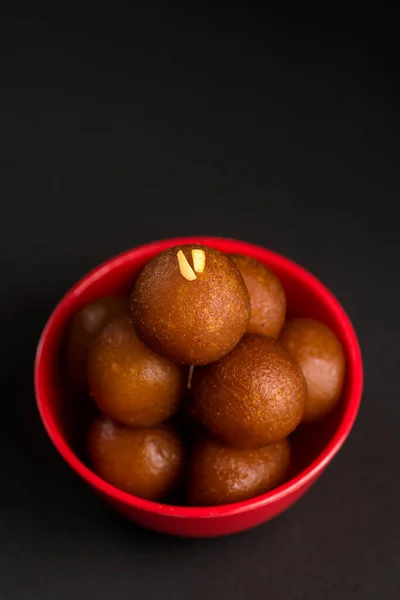 Gulab jamun in einer Schüssel auf schwarzem Hintergrund. indisches Dessert oder süßes Gericht. — Stockfoto