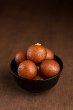 Hint Tatlısı ya da Tatlı Tabak: Ahşap arka planda Gulab Jamun.
