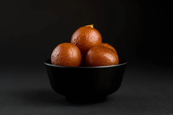 Gulab Jamun in ciotola su sfondo nero. Dessert indiano o piatto dolce . — Foto Stock