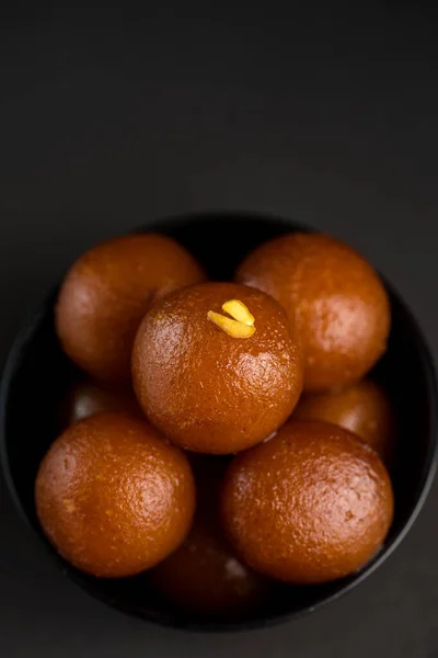 Gulab jamun in einer Schüssel auf schwarzem Hintergrund. indisches Dessert oder süßes Gericht. — Stockfoto