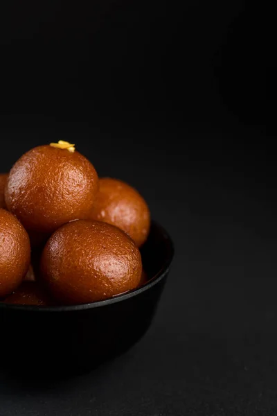 Gulab Jamun in ciotola su sfondo nero. Dessert indiano o piatto dolce . — Foto Stock