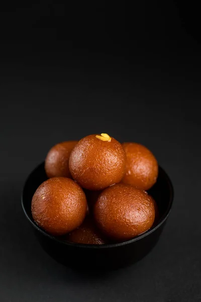 Gulab jamun in einer Schüssel auf schwarzem Hintergrund. indisches Dessert oder süßes Gericht. — Stockfoto