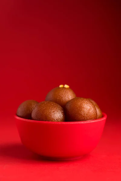 붉은 배경에 빨간 그릇에 감전된 채로 있습니다. 인도식 디저트나 달콤 한 음식. — 스톡 사진