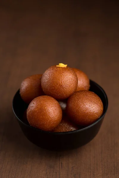 Postre indio o plato dulce: Gulab Jamun en tazón sobre fondo de madera . —  Fotos de Stock