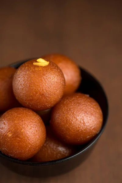 Indisches Dessert oder süßes Gericht: Gulab Jamun in Schale auf Holzgrund. — Stockfoto