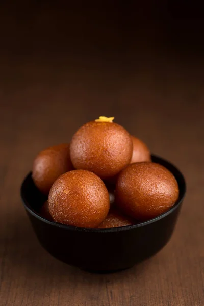 Postre indio o plato dulce: Gulab Jamun en tazón sobre fondo de madera . —  Fotos de Stock