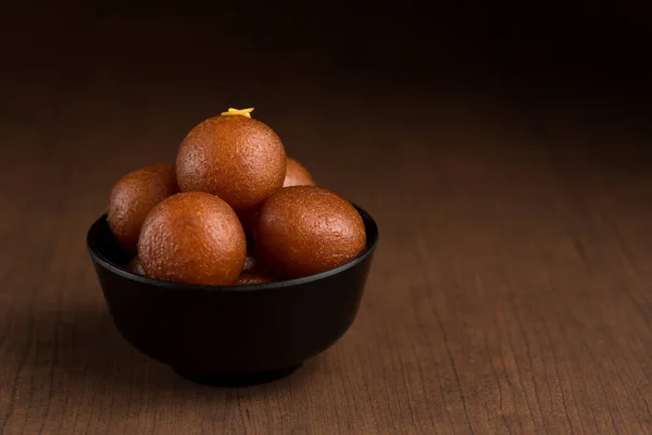 Indisches Dessert oder süßes Gericht: Gulab Jamun in Schale auf Holzgrund. — Stockfoto