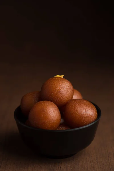 Postre indio o plato dulce: Gulab Jamun en tazón sobre fondo de madera . —  Fotos de Stock