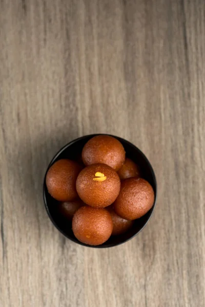 Postre indio o plato dulce: Gulab Jamun en tazón sobre fondo de madera . —  Fotos de Stock