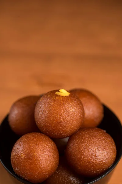 Indisches Dessert oder süßes Gericht: Gulab Jamun in Schale auf Holzgrund. — Stockfoto