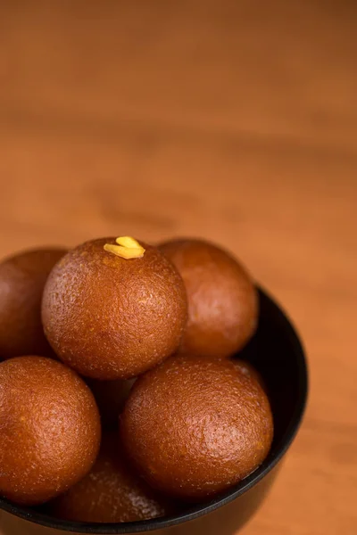 Indisches Dessert oder süßes Gericht: Gulab Jamun in Schale auf Holzgrund. — Stockfoto