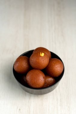 Hint Tatlısı ya da Tatlı Tabak: Ahşap arka planda Gulab Jamun.